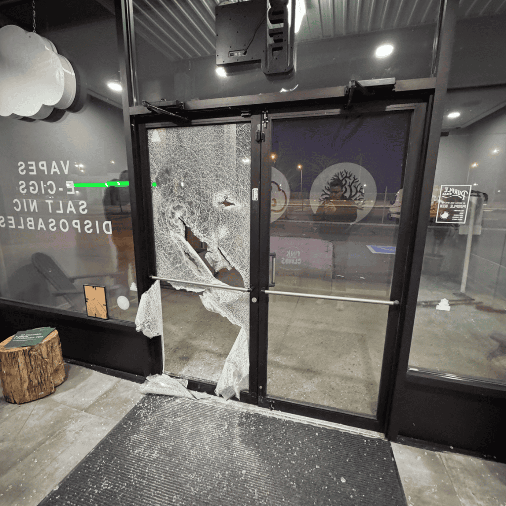 A storefront door smashed in the night, glass across the floor and the opening wide open.